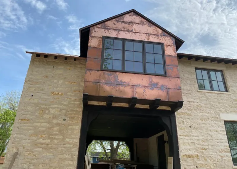 Copper metal panel facade on a stone building for Skylight Installation in Volo